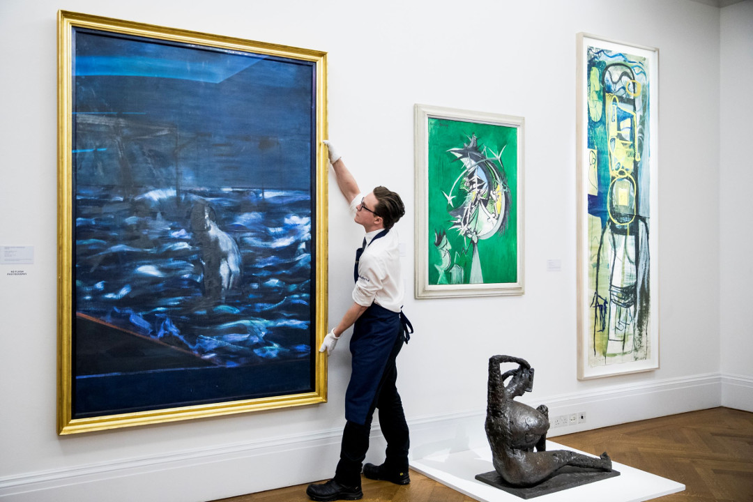 A Sotheby's employee handles Figure in Sea (1957) by Francis Bacon in the Brave New Visions exhibition