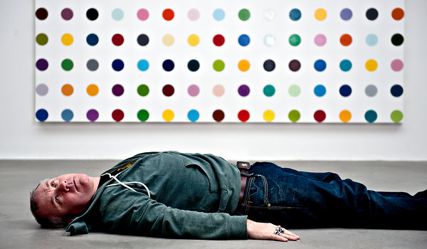 Damien Hirst in front of one of his spot paintings in 2011