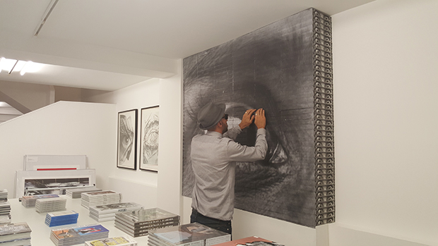 JR installs copies of his Phaidon book at his show Decade, in Paris.