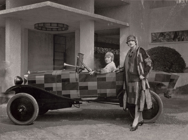 Two models wearing fur coats designed by Sonia Delaunay and manufactured by Heim, with the car belonging to the journalist Kaplan and painted after one of Sonia Delaunay’s fabrics, in front of the Pavillon du Tourisme designed by Mallet-Stevens, International Exposition of Modern Industrial and Decorative Arts, Paris 1925. Bibliothèque nationale de France