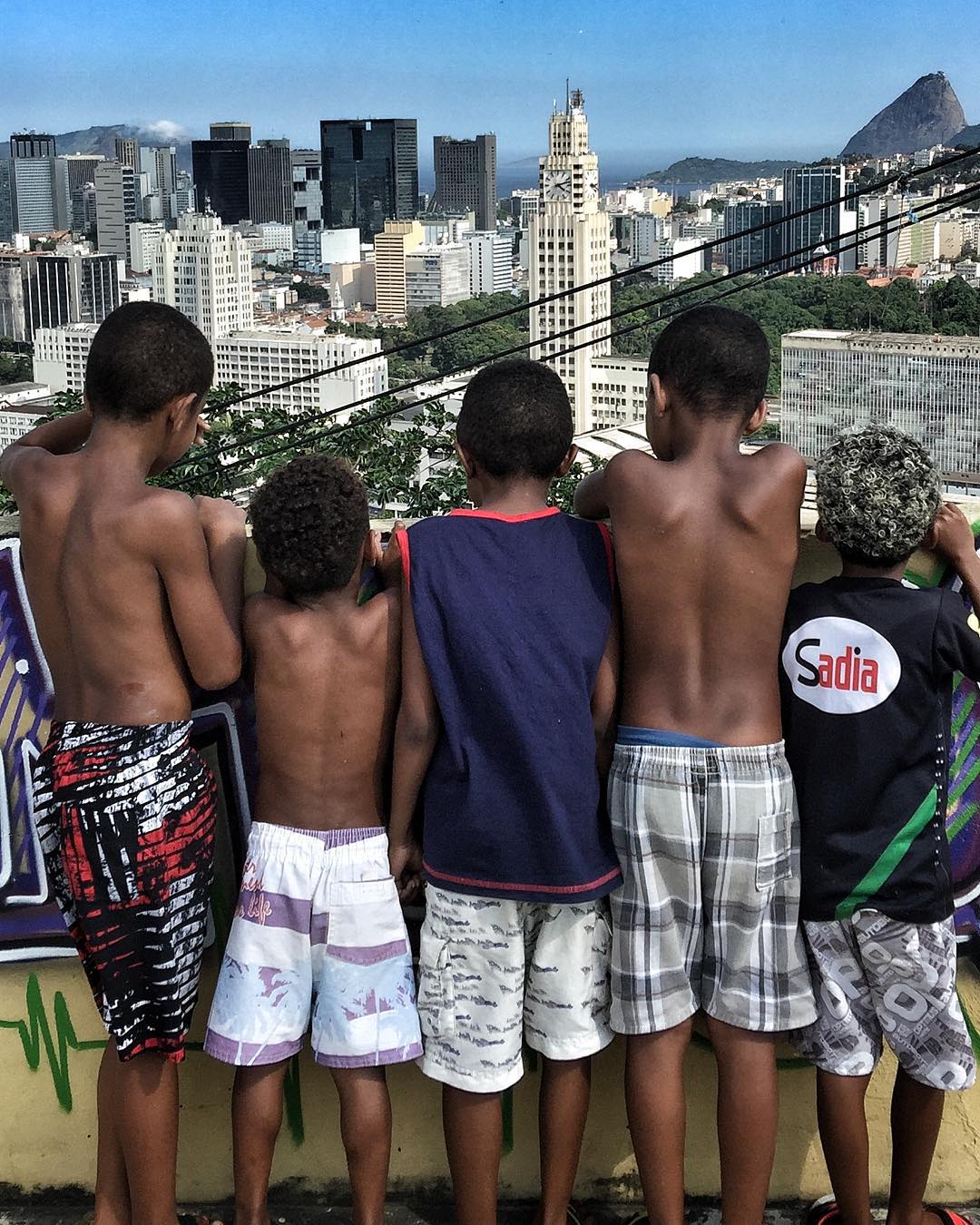 Local kids look down from the roof terrace at Casa Amarela. Image courtesy of JR's Instagram